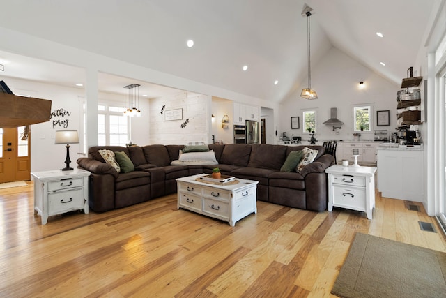 living room with high vaulted ceiling and light hardwood / wood-style floors