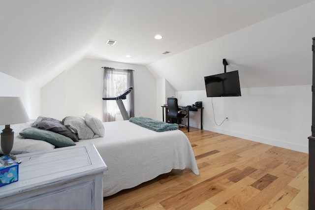 bedroom featuring light hardwood / wood-style flooring and lofted ceiling