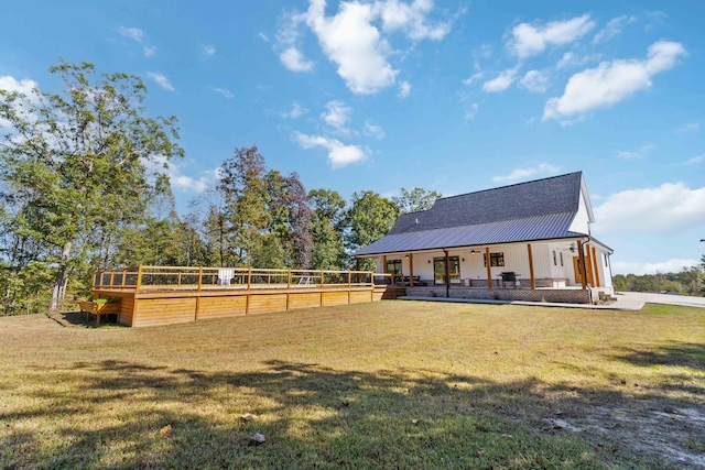 rear view of property featuring a yard and a porch