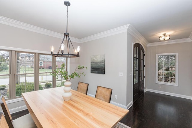 dining space featuring dark wood-type flooring, ornamental molding, baseboards, and an inviting chandelier