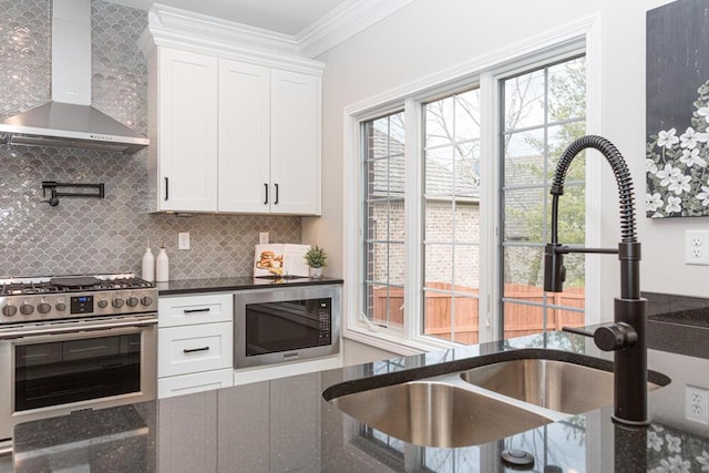 kitchen featuring a sink, built in microwave, wall chimney exhaust hood, gas range, and crown molding