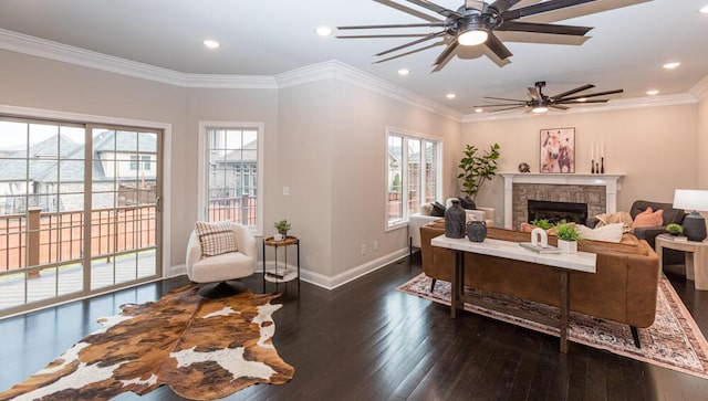 living room featuring ornamental molding, a healthy amount of sunlight, a fireplace, and hardwood / wood-style flooring