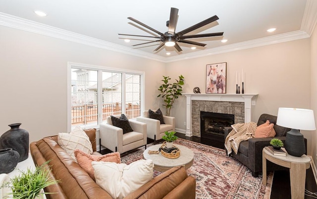 living room featuring ceiling fan, a stone fireplace, recessed lighting, wood finished floors, and ornamental molding