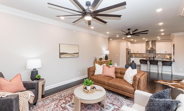 living room featuring baseboards, a ceiling fan, dark wood-type flooring, crown molding, and recessed lighting