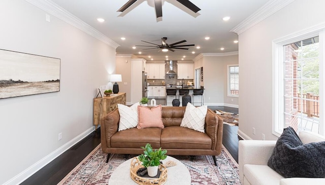 living area featuring recessed lighting, a ceiling fan, baseboards, dark wood-style floors, and crown molding