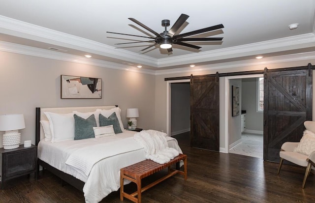 bedroom with a barn door, baseboards, wood finished floors, a tray ceiling, and recessed lighting