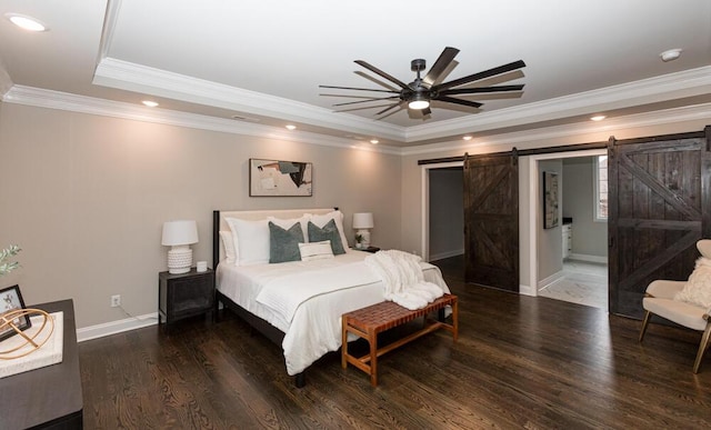 bedroom with a barn door, recessed lighting, wood finished floors, baseboards, and a raised ceiling