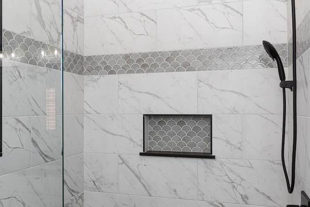 interior details featuring a tile shower