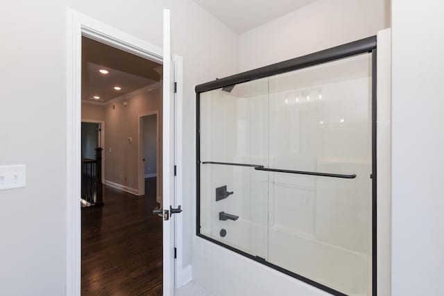 bathroom with enclosed tub / shower combo, recessed lighting, wood finished floors, baseboards, and crown molding