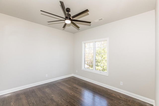 empty room with dark wood-style floors, baseboards, and visible vents