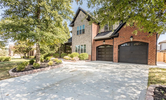 traditional home featuring a garage, concrete driveway, and brick siding