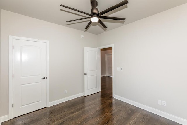 unfurnished bedroom with ceiling fan, dark wood finished floors, and baseboards