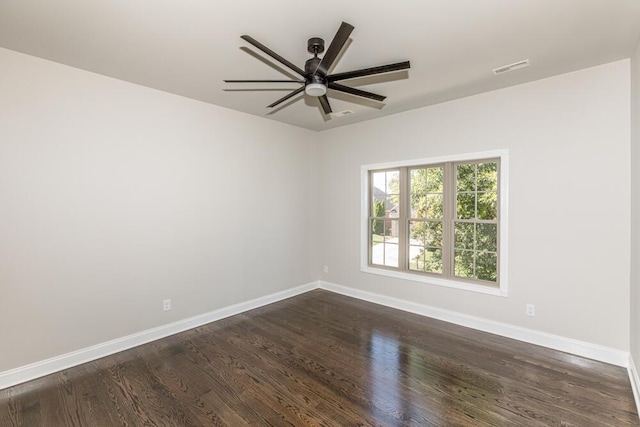 unfurnished room with visible vents, dark wood-type flooring, a ceiling fan, and baseboards