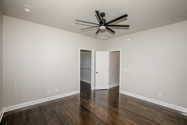 empty room with a ceiling fan, visible vents, baseboards, and wood finished floors