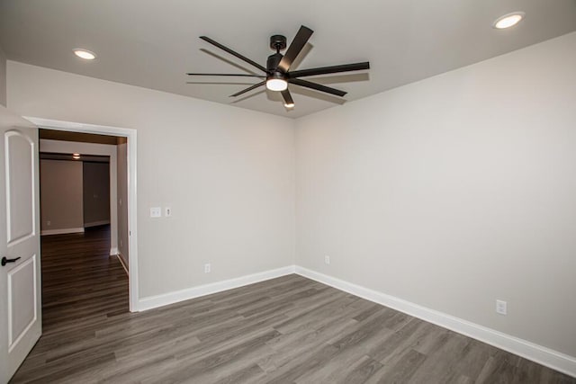 unfurnished room with recessed lighting, wood finished floors, and baseboards