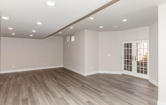 below grade area with baseboards, french doors, wood finished floors, and recessed lighting