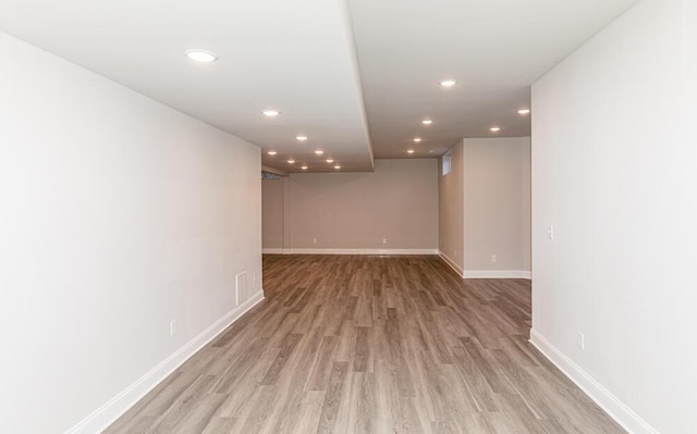 finished basement with light wood-style flooring, baseboards, and recessed lighting