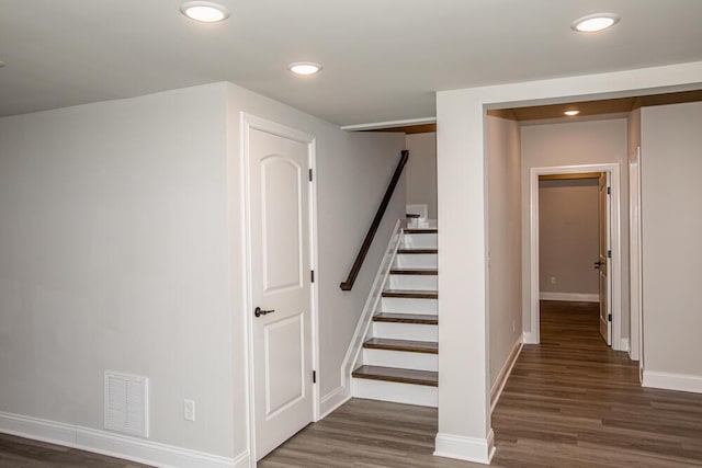 stairway featuring recessed lighting, wood finished floors, visible vents, and baseboards