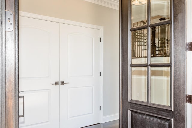 interior space with ornamental molding and baseboards