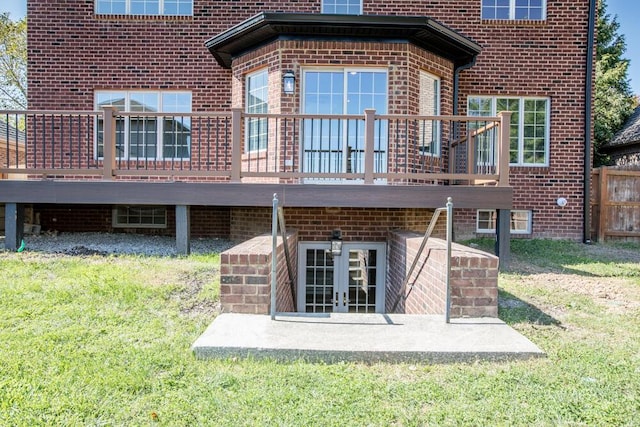 rear view of property featuring french doors, brick siding, and a deck