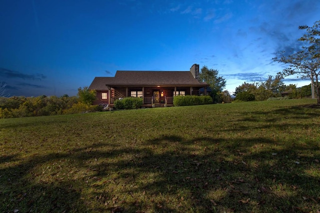 back of property featuring a porch and a yard