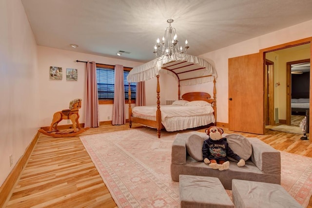 bedroom featuring an inviting chandelier and wood-type flooring