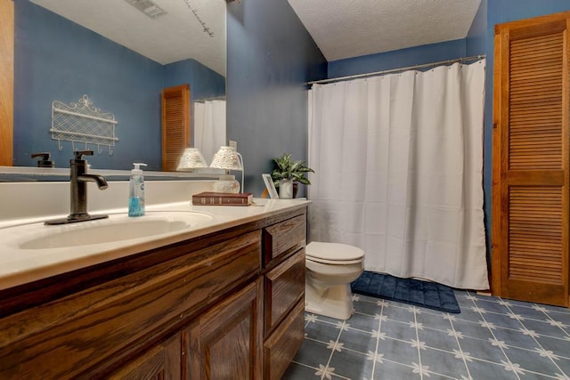 bathroom with vanity, toilet, and a textured ceiling