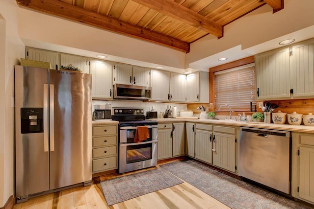 kitchen with light wood-type flooring, beamed ceiling, wood ceiling, sink, and appliances with stainless steel finishes