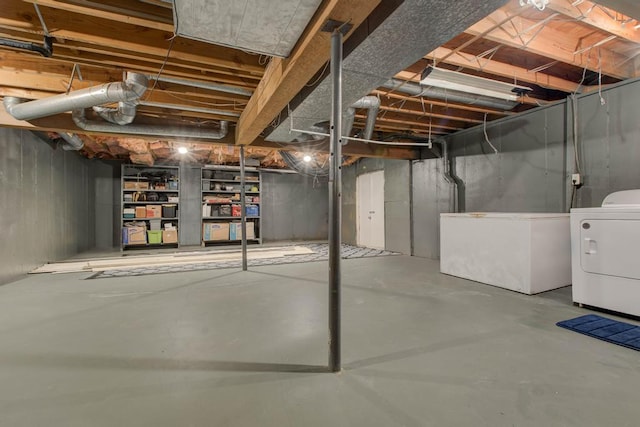 basement featuring washing machine and dryer and fridge