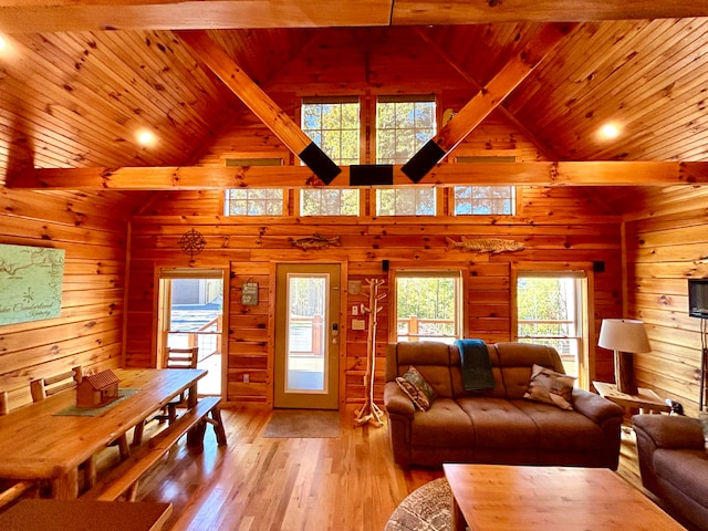 living room with light wood-type flooring, wood walls, high vaulted ceiling, and wooden ceiling