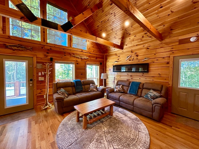 living room with beamed ceiling, wooden ceiling, light hardwood / wood-style flooring, wooden walls, and high vaulted ceiling