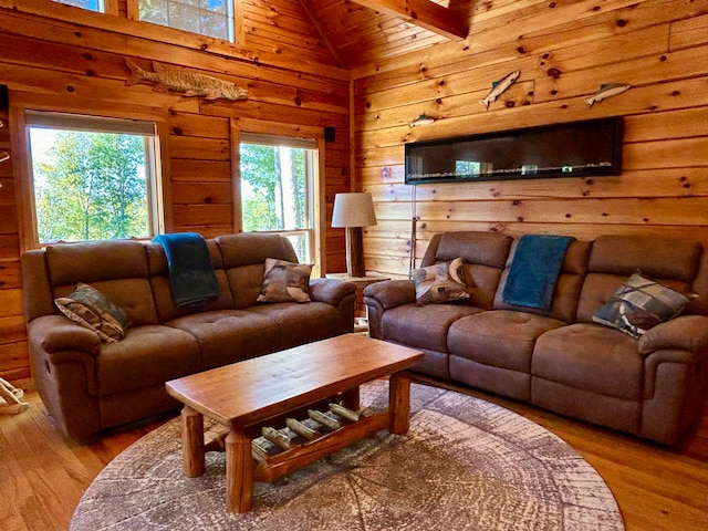 living room featuring lofted ceiling with beams, wooden walls, a wealth of natural light, and wood-type flooring