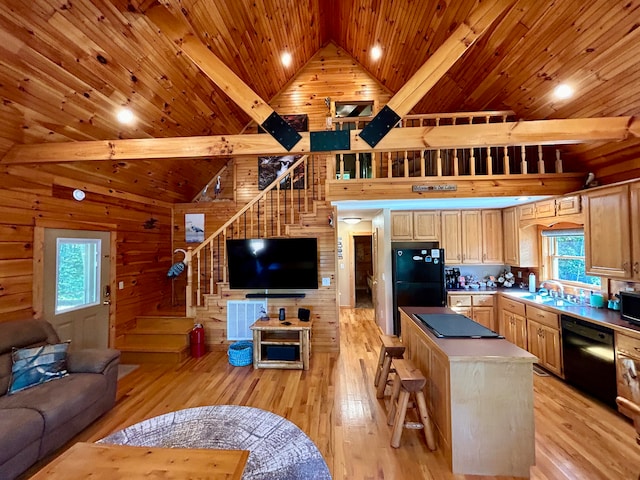 kitchen with a kitchen island, black appliances, high vaulted ceiling, and light hardwood / wood-style flooring