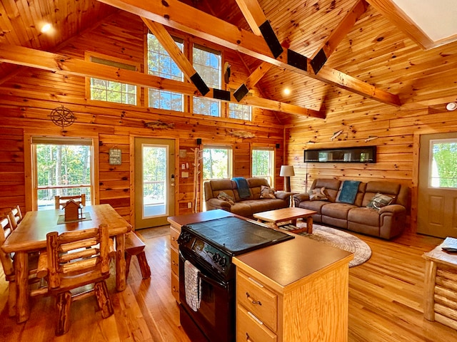 kitchen featuring black electric range, light hardwood / wood-style floors, high vaulted ceiling, and a healthy amount of sunlight