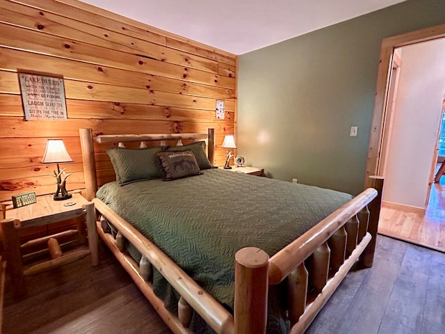 bedroom with wood walls and dark hardwood / wood-style flooring