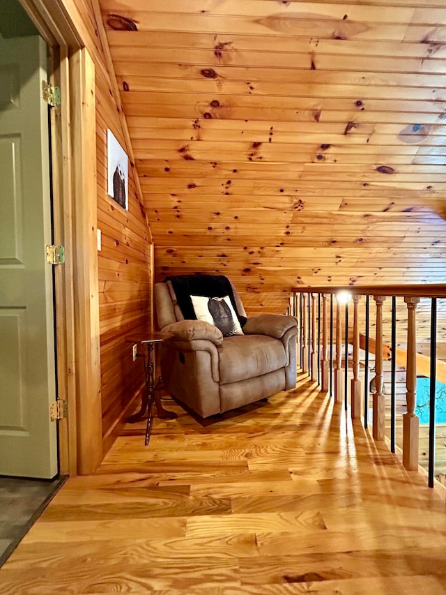 bonus room with light wood-type flooring, wood walls, vaulted ceiling, and wood ceiling