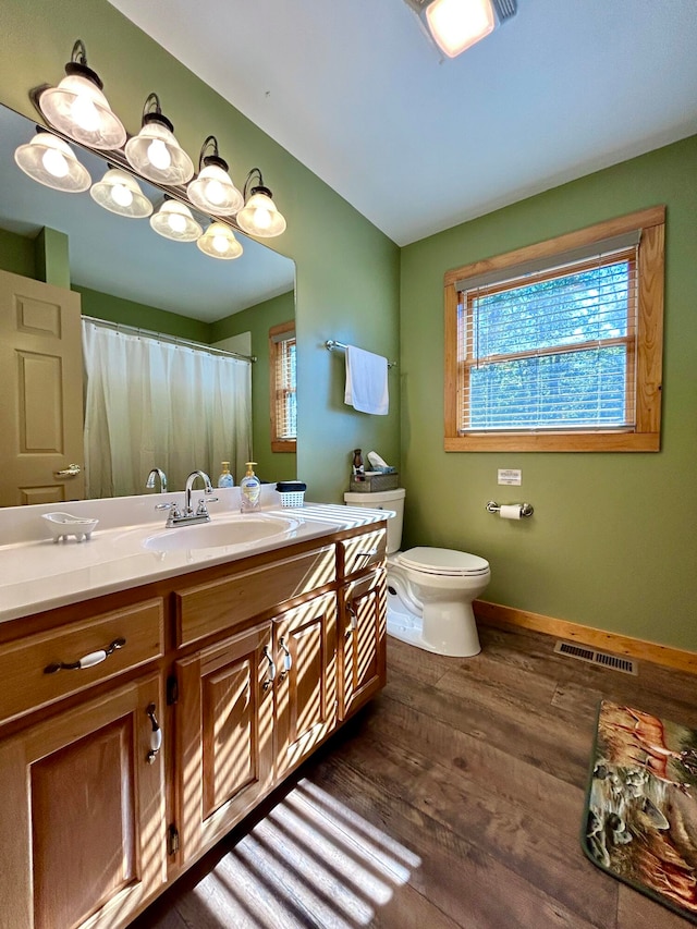 bathroom featuring wood-type flooring, vanity, and toilet