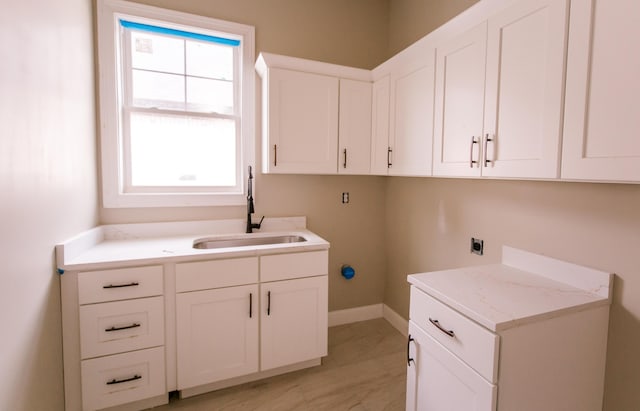 laundry area featuring cabinets, electric dryer hookup, and sink