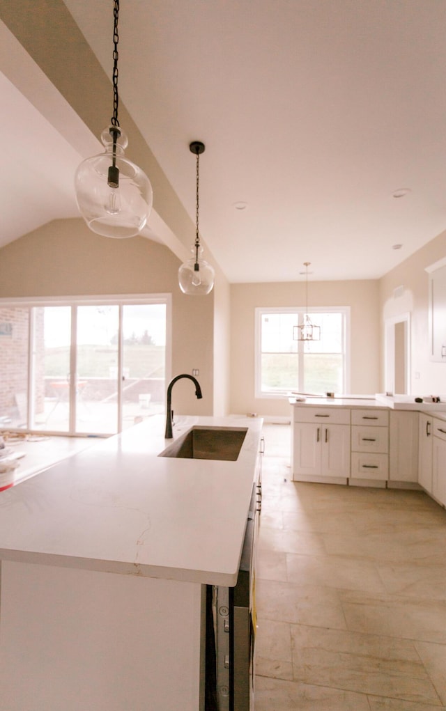 kitchen featuring white cabinets, sink, and hanging light fixtures