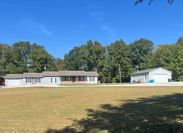 single story home with a front yard, a garage, and an outbuilding