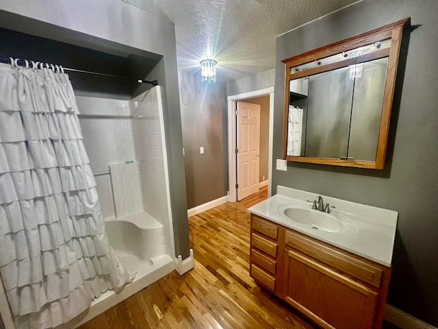 bathroom featuring a shower with curtain, vanity, hardwood / wood-style floors, and a textured ceiling