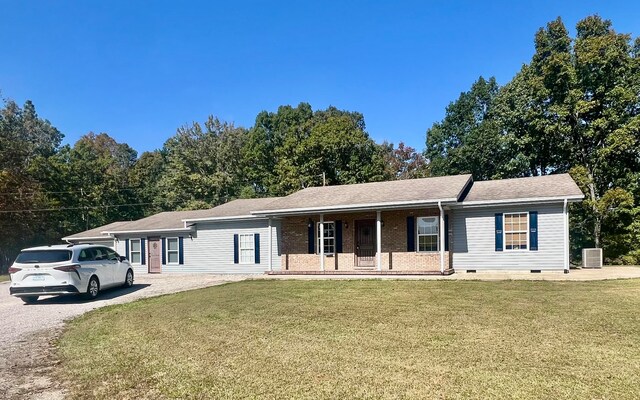 ranch-style home featuring a front lawn and central AC unit