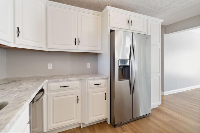 kitchen featuring light wood-style flooring, white cabinetry, a textured ceiling, and appliances with stainless steel finishes