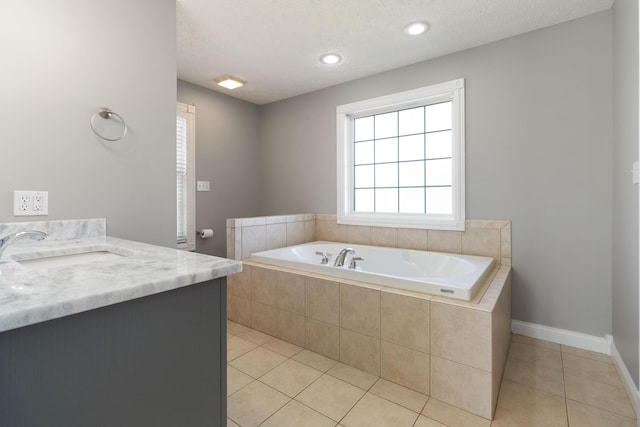 bathroom with vanity, baseboards, tile patterned flooring, a textured ceiling, and a bath
