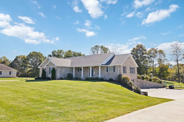 ranch-style home with brick siding, driveway, and a front lawn