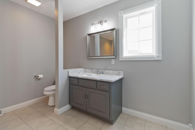 bathroom featuring tile patterned floors, toilet, vanity, and baseboards