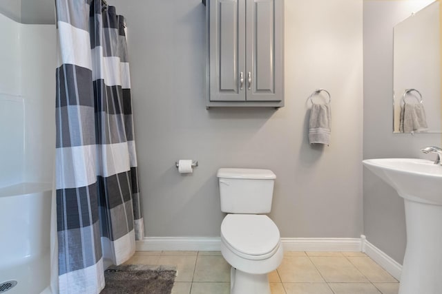 bathroom with toilet, curtained shower, and tile patterned flooring
