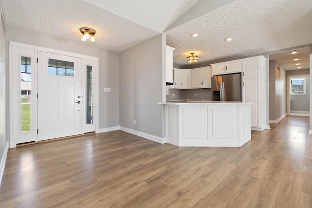 entryway with recessed lighting, light wood-type flooring, a textured ceiling, and baseboards