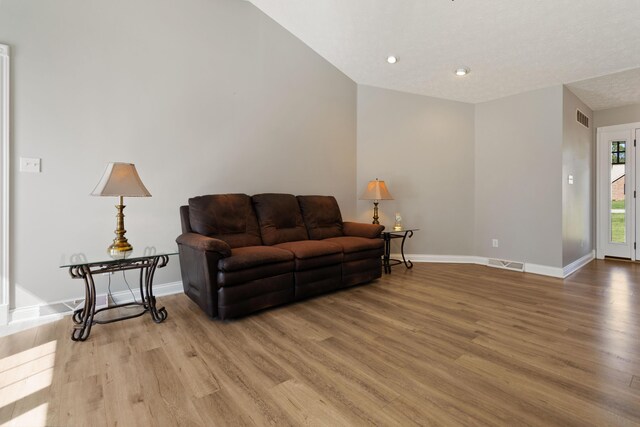 living room with visible vents, baseboards, and wood finished floors