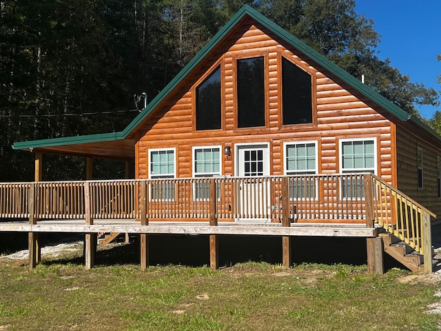 rear view of house featuring a lawn and a deck